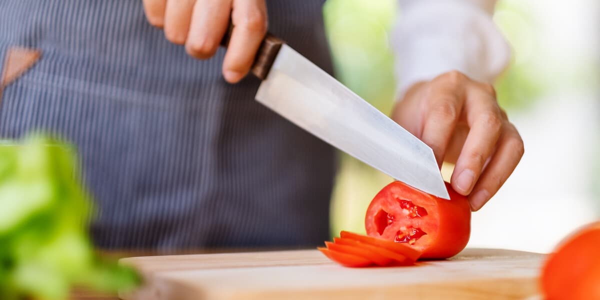 Chef cutting tomato